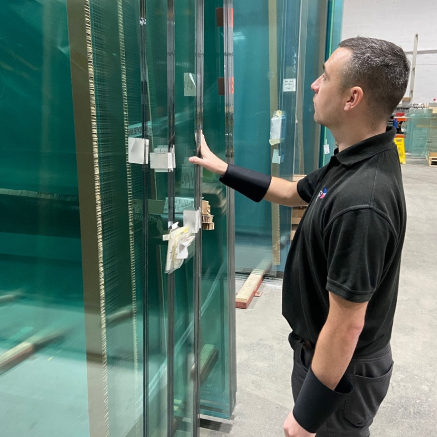 PLG staff looking at large glass panels